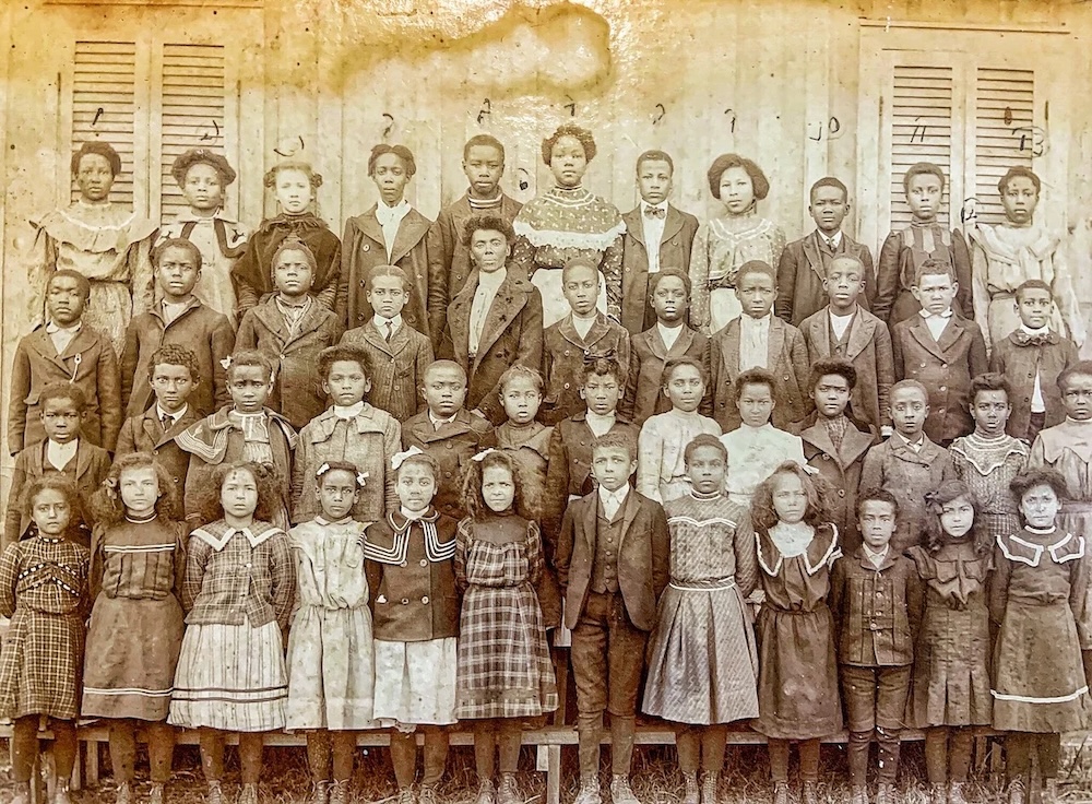 Historic class photograph of Black schoolchildren of Iberia Parish standing in rows outside a schoolhouse